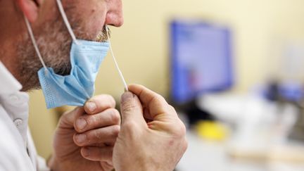 Un homme pratique un autotest nasopharyngé au coronavirus le 22 novembre 2021 (Photo d'illustration). (MATTHIAS BALK / DPA)