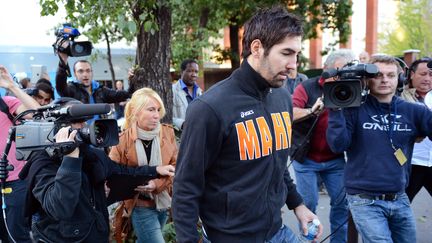 Le handballeur Nikola Karabatic, escort&eacute; par une polici&egrave;re, &agrave; la sortie de la salle Pierre-de-Coubertin, le 30 septembre 2012 &agrave; Paris. (FRANCK FIFE / AFP)