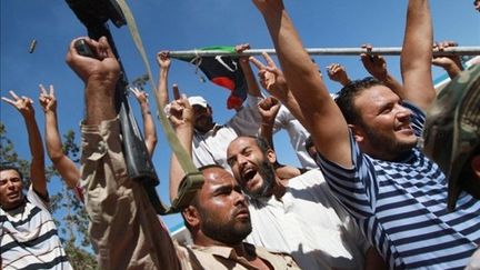 Des insurgés libyens fêtent leur entrée dans la ville de Bir Terfas le 13 août dernier. (MARC HOFER / AFP)