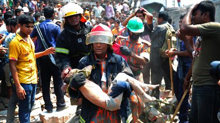 Les secours &eacute;vacuent de premiers corps du Rana Plaza, le 24 avril 2013, &agrave; Savar, apr&egrave;s l'effondrement de cet immeuble de neuf &eacute;tages. (MUNIR UZ ZAMAN / AFP)