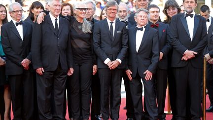 À l'occasion du 70e anniversaire du festival, les photographes et fans ont pu se régaler en immortalisant cette brochette de Palmes d'or, véritables légendes du cinéma, posant simplement sur le tapis rouge presque comme une bande de copains. De gauche à droite : le réalisateur Ken Loach, palme d'or l'an dernier avec "Moi, Daniel Blake", l'américain David Lynch qui fait son retour à Cannes avec la 3e saison de la série cultissime "Twin Peaks", la réalisatrice néo-zélandaise Jane Campion, qui présentait aujourd'hui la deuxième saison de sa série "Top of the Lake", le suédois Bille August récompensé en 1992 pour "Les meilleures intentions", le franco-polonais Roman Polanski  auréolé de sa Palme d'or obtenue en 2002 avec "La Pianiste", et pour compléter le tout, le réalisateur italien Nanni Moretti, qui l'avait emportée juste avant Roman Polanski, avec "La Chambre du fils", en 2001.
 (Valéry Hache / AFP)