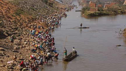 Des centaines de personnes nettoient leurs v&ecirc;tements dans&nbsp;la rivi&egrave;re Ikopa pr&egrave;s d'Antananarivo, la capitale de Madagascar, le 25 octobre 2013. (SCHALK VAN ZUYDAM / AP / SIPA)