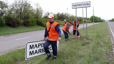 Des travailleurs municipaux ont changé les panneaux routiers ukrainiens en panneaux russes à l'extérieur de la ville de Mariupol, le&nbsp;5 mai 2022.&nbsp; (DONETSK PEOPLE REPUBLIC MINISTRY)