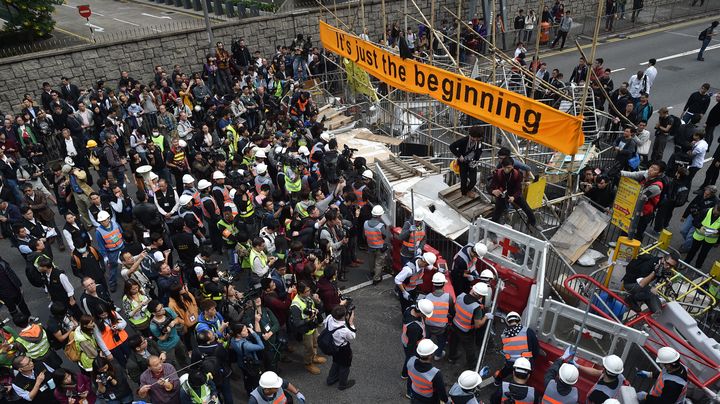 Les m&eacute;dias observent les autorit&eacute;s en train de d&eacute;monter le camp d'occupation des manifestants, le 11 d&eacute;cembre 2014, &agrave; Hong Kong. (PEDRO UGARTE / AFP)