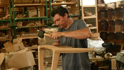 Un employé de la menuiserie qui a été choisie pour fabriquer les 1500 chaises de la Cathédrale Notre-Dame rénovée, le 11 septembre 2023 (GAIZKA IROZ / AFP)