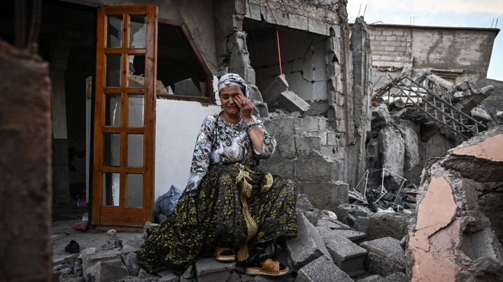 Une survivante du tremblement de terre du 8 septembre, pleure assise sur les décombres de sa maison endommagée, dans le village de montagne de Moulay Brahim, dans la province d'Al Haouz, dans le centre du Maroc, le 10 septembre 2023. (PHILIPPE LOPEZ / AFP)