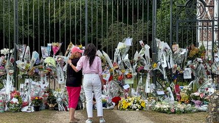 Anouchka Delon (right), stands in front of dozens of bouquets of flowers placed at the entrance to her father Alain Delon's property in Douchy (Loiret), on August 21, 2024. (TOM MASSON / AFP)