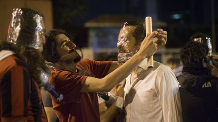 Des manifestants se prot&egrave;gent le visage avec du film plastique lors d'affrontements avec la police turque &agrave; Istanbul (Turquie), le 4 juin 2013. (URIEL SINAI / GETTY IMAGES)