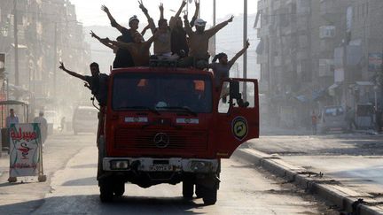 Des rebelles syriens célèbrent  la fin du siège d'Alep dans les rues de la ville. (THAER MOHAMMED / AFP)