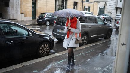 A passerby in the rain in the streets of Paris, February 22, 2024. (LAURE BOYER / HANS LUCAS / AFP)