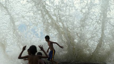 Des enfants jouent avec les&nbsp;vagues sur la plage de Dili (Timor Oriental), le 15 mars 2012. (BEAWIHARTA  / REUTERS  )