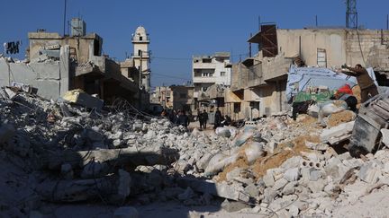 Des Syriens au milieu des décombres de bâtiments effondrés à Atarib, village à l'ouest d'Alep, le 14 février 2023. (AAREF WATAD / AFP)