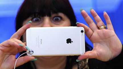 Une femme prend une photo avec un iPhone 6, le 19 septembre 2014, &agrave; Sydney (Australie).&nbsp; (DAVID GRAY / REUTERS)