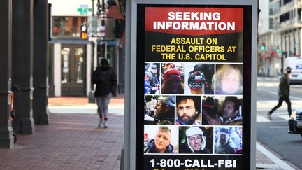 Des appels à témoins pour identifier les partisans de Donald Trump qui ont blessé des policiers lors des violences au Capitole sont affichés dans les rues de Washington, le 16 janvier 2021. (JOE RAEDLE / GETTY IMAGES NORTH AMERICA / AFP)