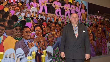 Le collectionneur d'art africain Jean Pigozzi devant une peinture de Moké ("Nuit chande à la Cité", 1999), au vernissage de l'exposition "Art Afrique", à la Fondation Louis Vuitton à Paris, le 25 avril 2017 (PASCAL LE SEGRETAIN / GETTY IMAGES EUROPE)