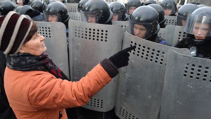 Une femme s'adresse &agrave; des policiers, le 14 janvier 2014, &agrave; Kiev (Ukraine), lors d'une manifestation de victimes de l'accident nucl&eacute;aire de Tchernobyl. (SERGEI SUPINSKY / AFP)