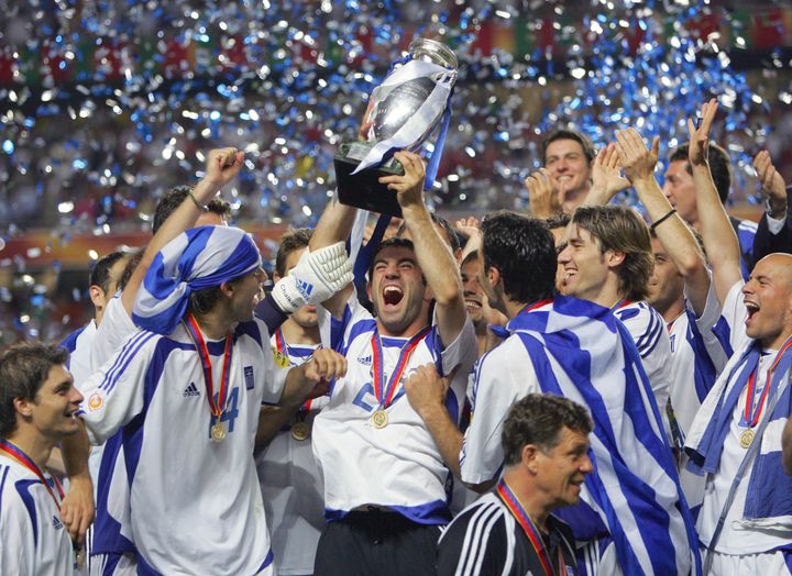 Georgios Karagounis et les Grecs soulèvent le trophée de l'Euro après leur victoire contre le Portugal, le 4 juillet 2004 à Lisbonne. (SORIANO/FIFE / AFP)