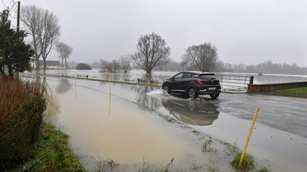 Une voiture roule sur une route inondée à Caudescure (Nord). (MAXPPP)