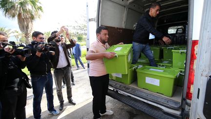 Des employés portent des cartons de 60 000 signatures de citoyens, nécessaires à la candidature de l'ancien Premier ministre algérien Abdelmadjid Tebboune, à l'Autorité électorale nationale indépendante à Alger, le 26 octobre 2019. (BILLAL BENSALEM / NURPHOTO)