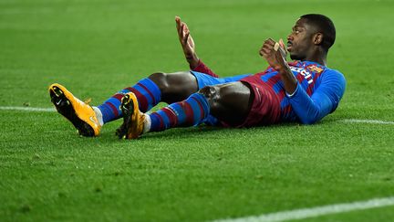 Ousmane Dembélé au sol sur la pelouse du Camp Nou lors d'un match de championnat face à Elche, le 18 décembre 2021. (PAU BARRENA / AFP)