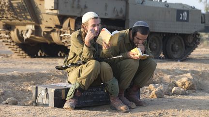 Deux soldats isra&eacute;liens r&eacute;servistes pendant leur pri&egrave;re du matin,&nbsp;le 20 novembre 2012,&nbsp;pr&egrave;s de la fronti&egrave;re entre Isra&euml;l et la bande de Gaza. (JACK GUEZ / AFP)