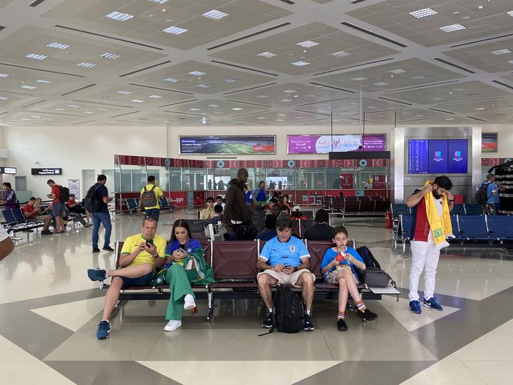 Des supporters patientent dans le hall de l'aéroport international de Doha (Qatar), le 2 décembre 2022. (RAPHAEL GODET / FRANCEINFO)