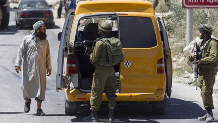 Des soldats isra&eacute;liens fouillent un v&eacute;hicule dans la ville palestinienne de H&eacute;bron (Cisjordanie), le 15 juin 2014, apr&egrave;s le rapt de trois jeunes isra&eacute;liens.&nbsp; (BAZ RATNER / REUTERS)