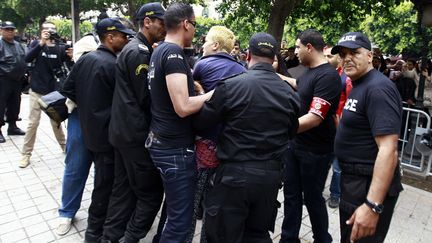 La Femen tunisienne Amina Tyler (au centre) mise &agrave; l'&eacute;cart par la police lors d'une manifestation,&nbsp;&agrave; Tunis (Tunisie), le 1er mai 2013. (ANIS MILI / REUTERS)