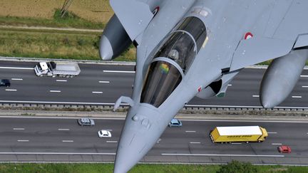 Un avion Rafale survole l'autoroute lors des r&eacute;p&eacute;titions du d&eacute;fil&eacute; militaire du 14-juillet entre Istres&nbsp;(Bouches-du-Rh&ocirc;ne) et Paris, le 9 juillet 2012. (BORIS HORVAT / AFP)