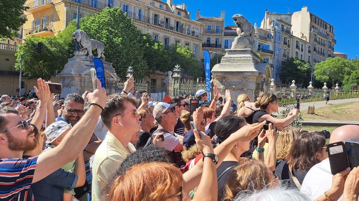 La foule brandit son téléphone dans les allées du parc Longchamp à Marseille (Bouches-du-Rhône), le 9 mai 2024, pour immortaliser l'arrivée de la flamme olympique.  (RAPHAËL GODET / FRANCEINFO)