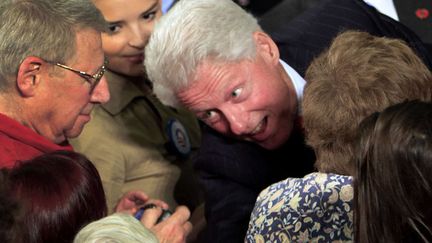 L'ancien pr&eacute;sident des Etats-Unis Bill Clinton se penche pour serrer des mains &agrave; Durham (New Hampshire), le 3 octobre 2012. (JIM COLE / AP / SIPA)