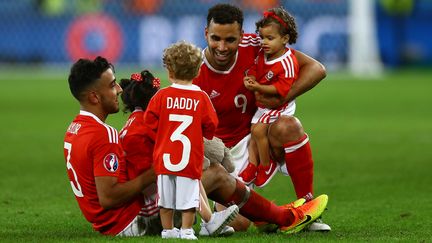 Les joueurs gallois Neil Taylor et Hal Robson-Kanu avec leurs enfants sur la pelouse du stade Pierre Mauroy de Lille, après leur victoire contre la Belgique, le 1er juillet 2016. (KIERAN MCMANUS / AFP)