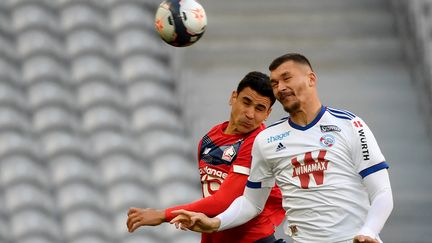 Benjamin André et Ludovic Ajorque se battent pour le ballon. (DENIS CHARLET / AFP)