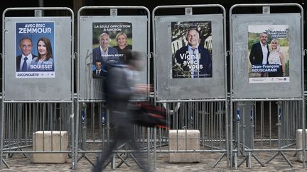 Une personne passe devant des affiches électorales avant les législatives, à Montpellier le 8 juin 2022. (PASCAL GUYOT / AFP)