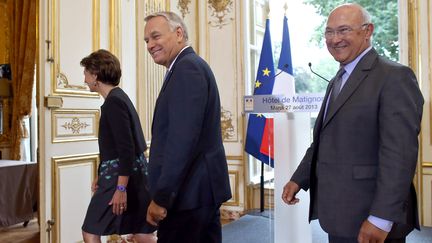 Le Premier ministre, Jean-Marc Ayrault (C), avec le ministre du Travail, Michel Sapin (D), apr&egrave;s la pr&eacute;sentation de la r&eacute;forme des retraites, le 27 ao&ucirc;t 2013 &agrave; Matignon. (KENZO TRIBOUILLARD / AFP)