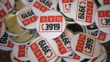 Des badges avec le numéro d'urgence 3919, créé pour lutter contre les violences conjugales. (ERIC FEFERBERG / AFP)