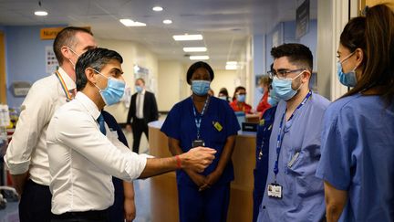 Le Premier ministre britannique Rishi Sunak parle avec&nbsp;des soignats&nbsp;lors de sa visite à l'hôpital universitaire de Croydon, à Londres, le 28 octobre 2022. (LEON NEAL / GETTY IMAGES EUROPE)