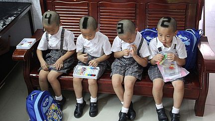 Afin de faciliter la t&acirc;che de leurs professeurs, ces quadrupl&eacute;s ont re&ccedil;u une coupe de cheveux permettant de les diff&eacute;rencier ais&eacute;ment, Shenzhen (Chine), le 3 septembre 2012. (AFP)