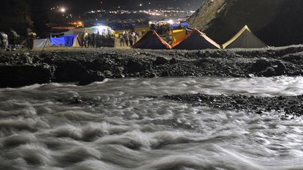 Avant de p&eacute;n&eacute;trer dans la grotte, les p&egrave;lerins se jettent dans le torrent glacial de l'Amravati afin de se purifier. (TAUSEEF MUSTAFA / AFP)