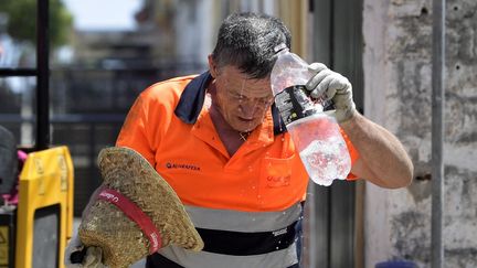 Un homme s'arrose d'eau fraîche à Séville (Espagne), le 17 juillet 2023. (CRISTINA QUICLER / AFP)