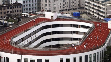 Des &eacute;l&egrave;ves s'entra&icirc;nent sur une piste d'athl&eacute;tisme construite sur le toit d'une &eacute;cole primaire &agrave; Tiantai (Chine), le 1er septembre 2014. ( CHINA DAILY / REUTERS)