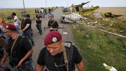 Des rebelles prorusses gardent un des lieux o&ugrave; sont tomb&eacute;s les d&eacute;bris de l'avion de la Malaysia Airlines, crash&eacute; dans l'est de l'Ukraine, le 20 juillet 2014. (MAXIM ZMEYEV / REUTERS)