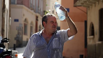 Un homme se rafra&icirc;chit dans les rues de Perpignan (Pyr&eacute;n&eacute;es-Orientales), le 17 ao&ucirc;t 2012. (RAYMOND ROIG / AFP)