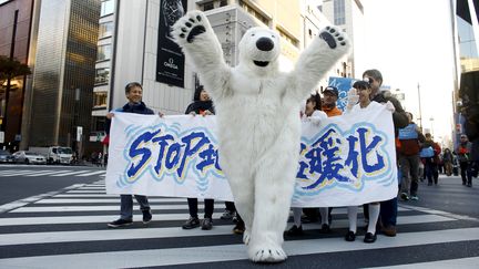 A Tokyo (Japon), la marche pour le climat était menée par un ours polaire, samedi 28 novembre. (THOMAS PETER / REUTERS)