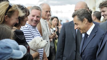 Nicolas Sarkozy salue des vacanciers au Cap d'Agde (H&eacute;rault), le 26 juillet 2011. (ERIC FEFERBERG / AFP)