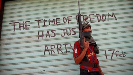 Un rebelle libyen devant une boutique fermée dans la ville de Zawiyah, à 40 km à l'ouest de Tripoli (AFP PHOTO/MARC HOFER)