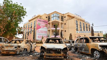 Des voitures incendiées devant le siège du parti politique du président Mohamed Bazoum, le 7 août 2023 à Niamey (Niger). (AFP)