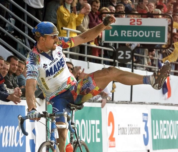 En 2000, le Belge Johan Museeuw passe la ligne d'arrivée de Paris-Roubaix en vainqueur et montre sa jambe, dont il avait failli être amputé après une chute à Arenberg deux ans plus tôt. (PATRICK KOVARIK / AFP)