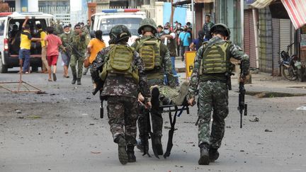 Des soldats évacuent un militaire blessé, après un double attentat survenu dans la ville de Jolo, aux Philippines, le 24 août 2020. (NICKEE BUTLANGAN / AFP)