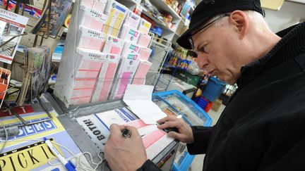 Un homme remplit un bulletin le 30 mars 2012, &agrave; New York, esp&eacute;rant empocher la cagnotte record de la loterie am&eacute;ricaine. (STAN HONDA / AFP)